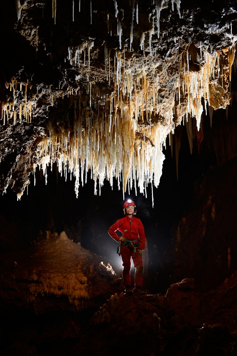 Grotte de Pousselières (Hérault) - Spéléologue devant un groupe de stalactites (salle de la comète) 