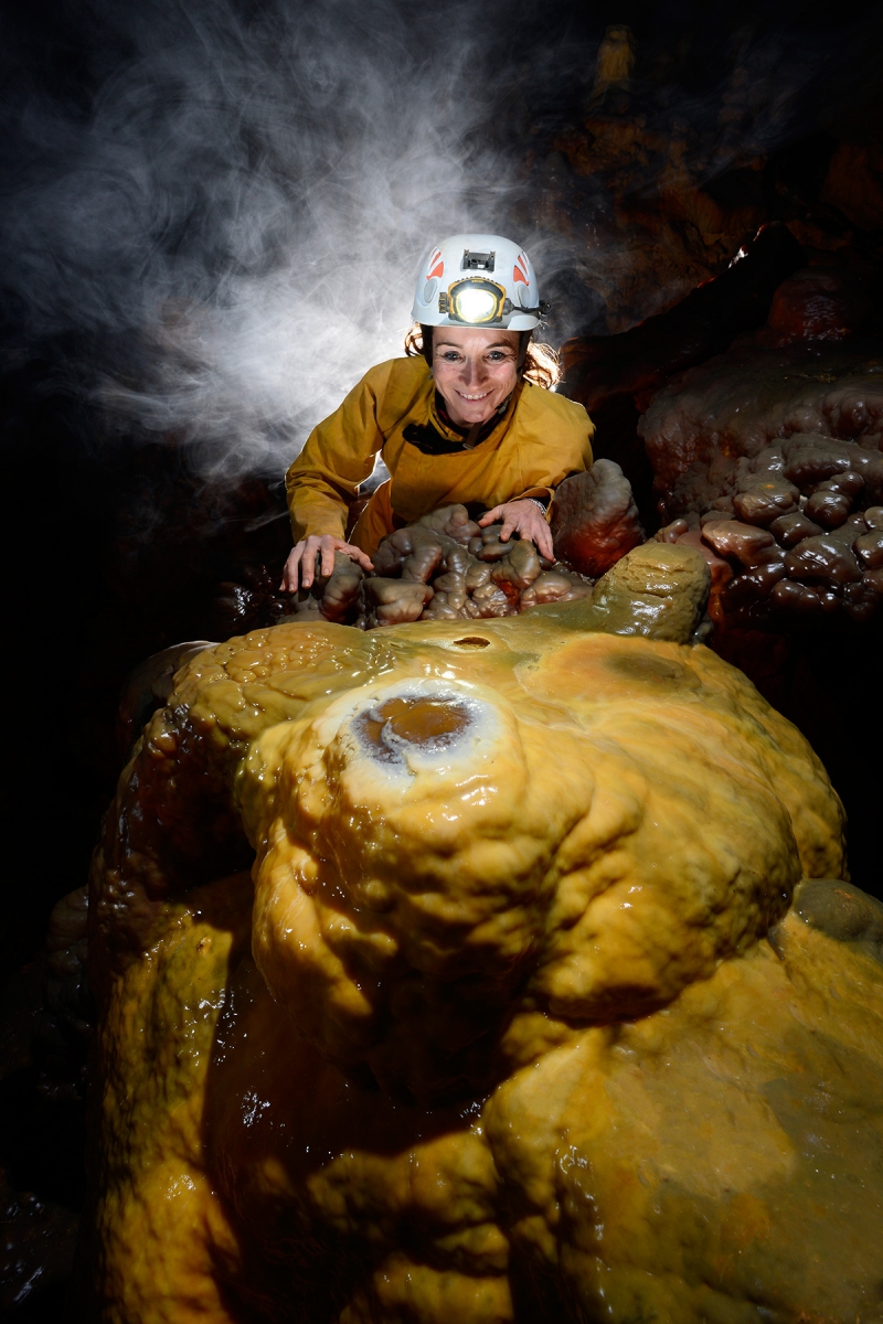 Grotte de Dargilan (Lozère) : femme avec buée devant massif stalagmitique jaune