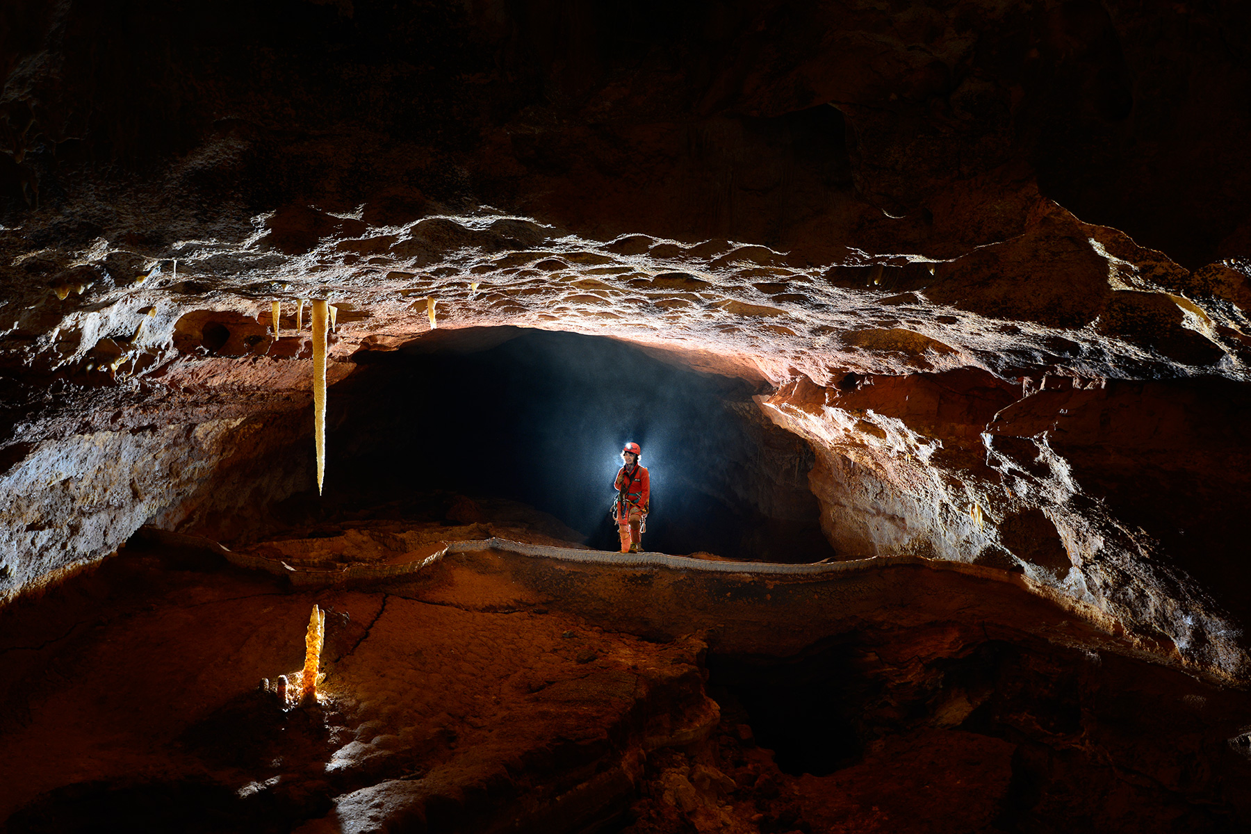 Grotte de Saint-Marcel d'Ardèche (réseau 4) - Galerie barrée par un gour géant (stalactite et stalagmite jaunes en contre jour au premier plan)