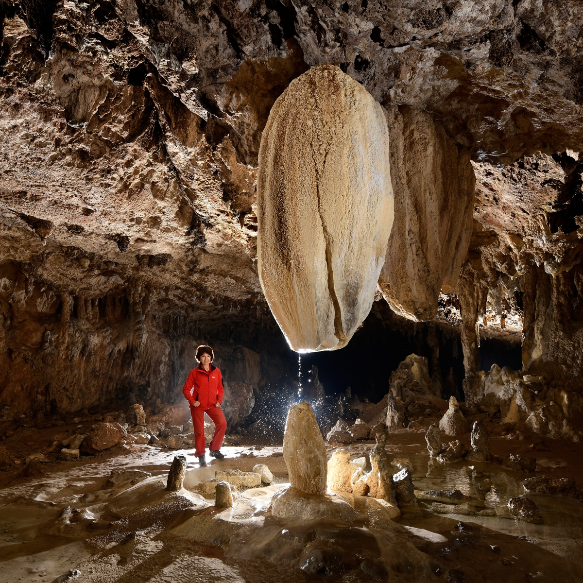 Grotte de Lombrives (Ariège) - "La Mamelle" : stalactite massive avec son filet d'eau éclatant sur la stalagmite dessous (vue de face)