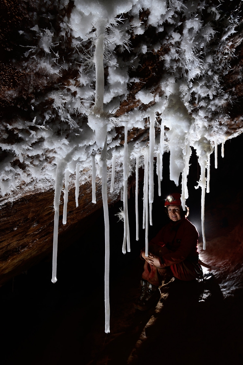 Grotte du Macoumé (Hérault) - Rideau de fistuleuses tubulaires d'aragonite avec spéléo en arrière plan