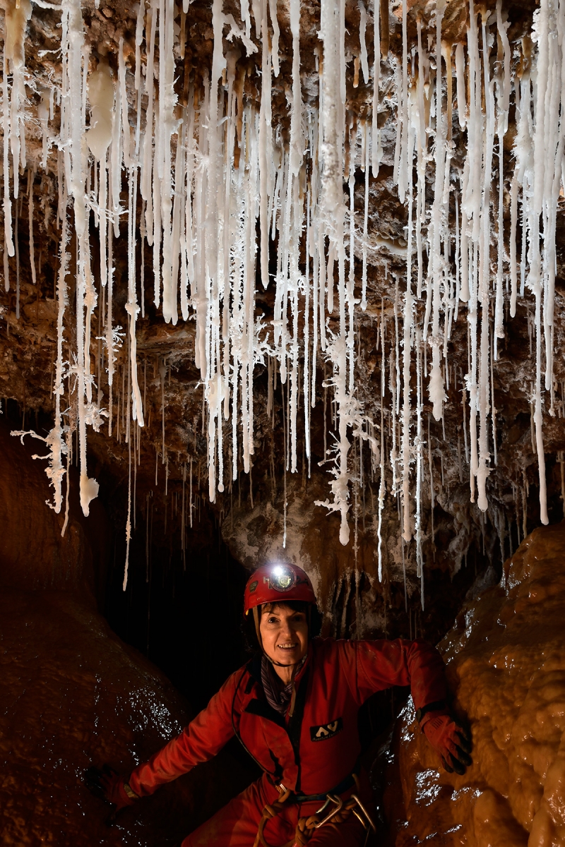 Grotte du Macoumé (Hérault) - Rideau de fistuleuses et d'aragonites avec personnage derrière