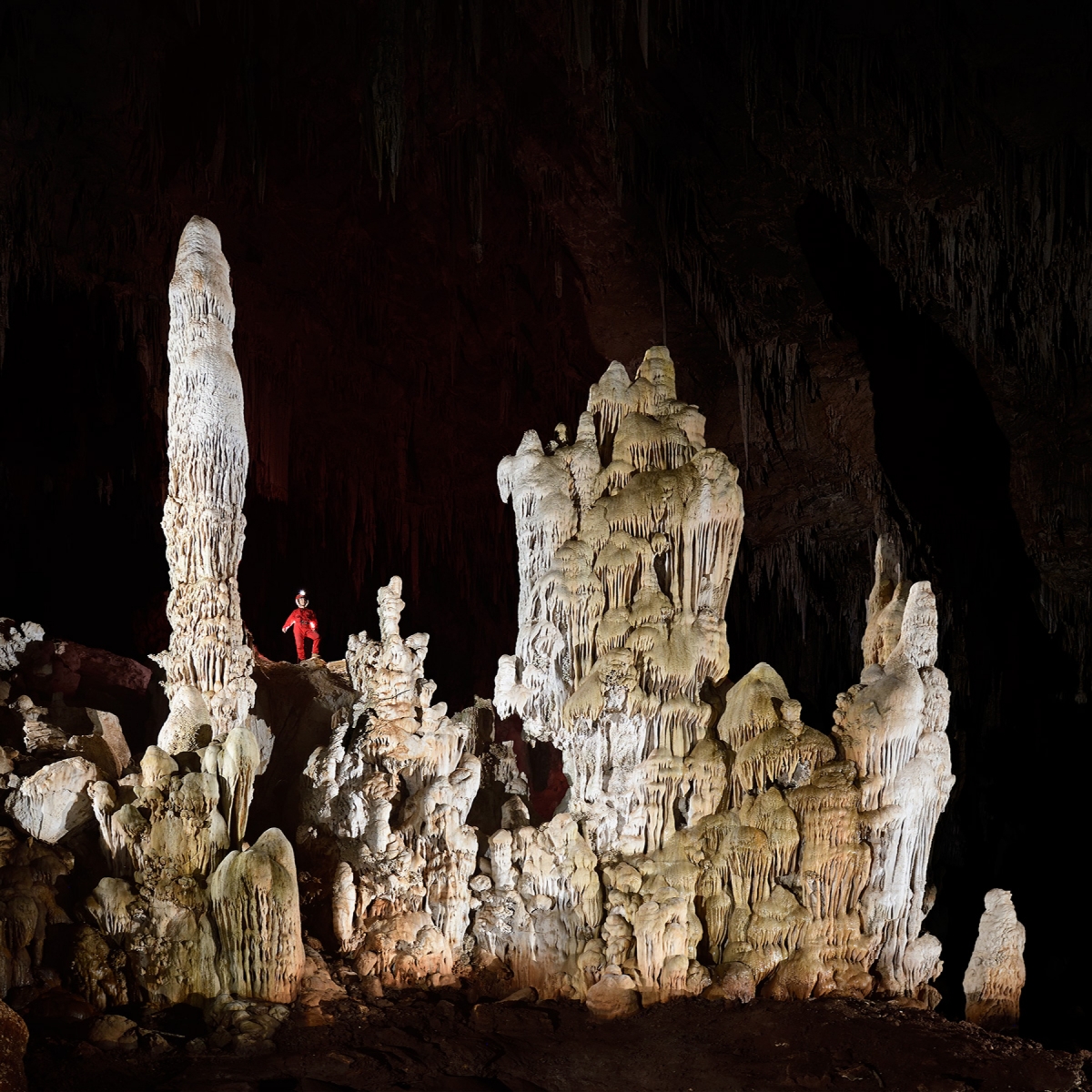 Gruta Nossa Sra. Aparecida (Mato Grosso do Sul, Brésil) - Grande barrière de stalagmites massives avec personnage en fond