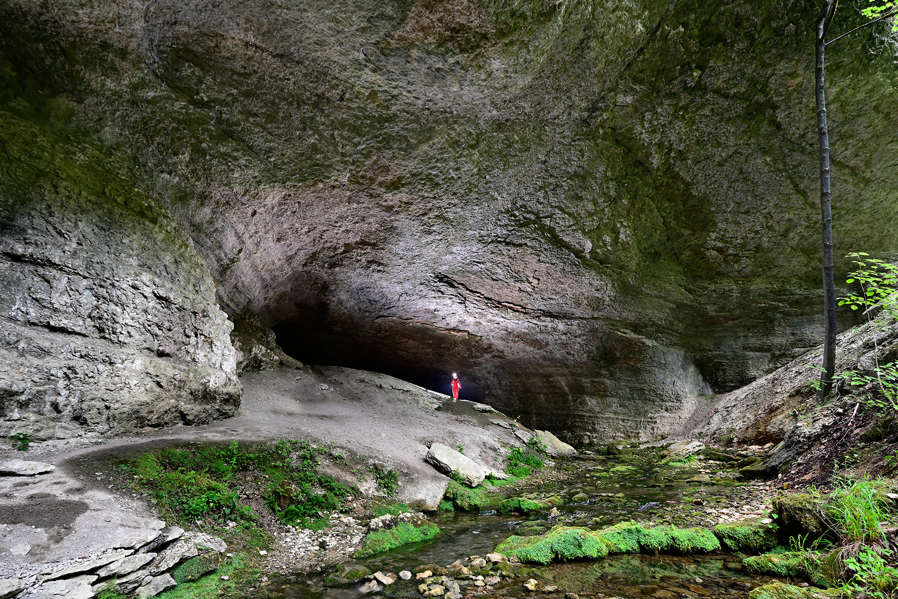 Grotte de Plaisir Fontaine (Doubs) - Porche d'entrée avec personnage vu de l'extérieur