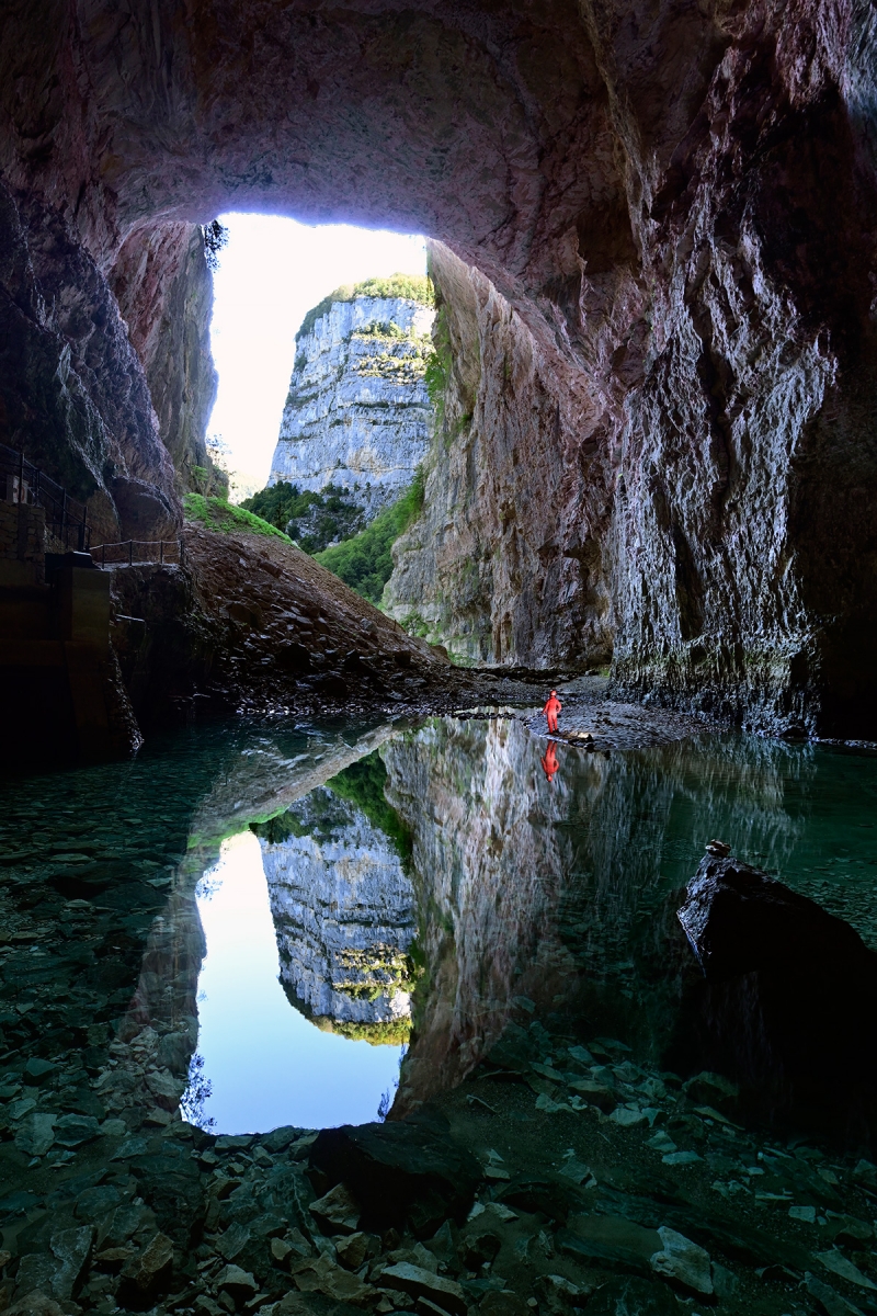 Grotte de Bournillon (Isère) - Porche d'entrée avec reflet des falaises des rochers de Presles dans le lac (verticale)