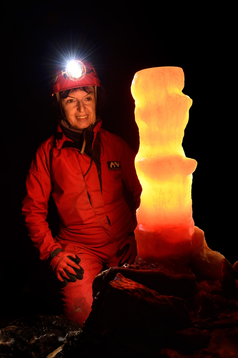 Grotte de Dargilan (Aveyron) - Salle du chaos : stalagmite éclairée en transparence avec spéléo à côté