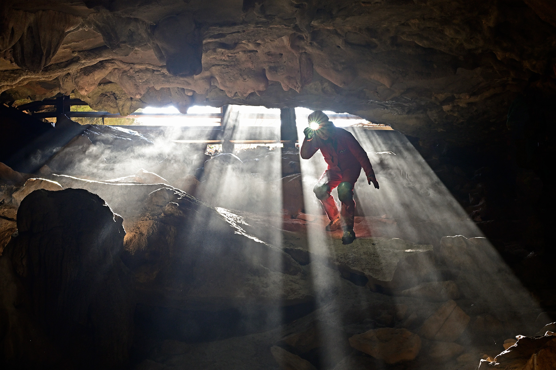 Rapps Cave (Virginie occidentale, USA) - Spéléo dans les rayons de soleil passant à travers la grille d'entrée 