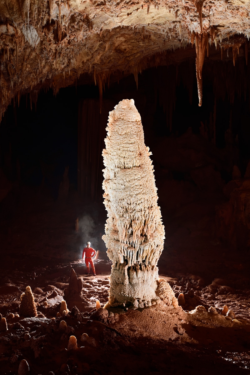 Réseaux non aménagés d'Orgnac-Issirac (Ardèche) - Grande stalagmite avec spéléo en fond dans la salle de la Grande barrière (réseau III)
