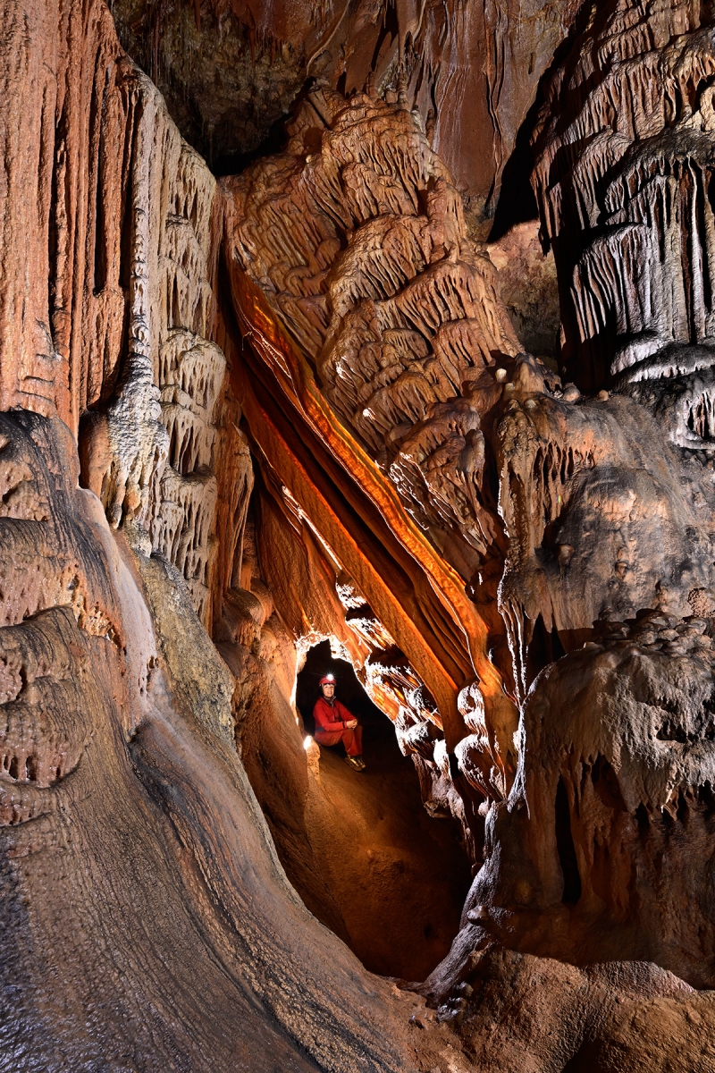 Grotte de Saint-Marcel d'Ardèche (réseau I) - Spéléo dans un passage sous un pilier effondré avec des draperies rectilignes