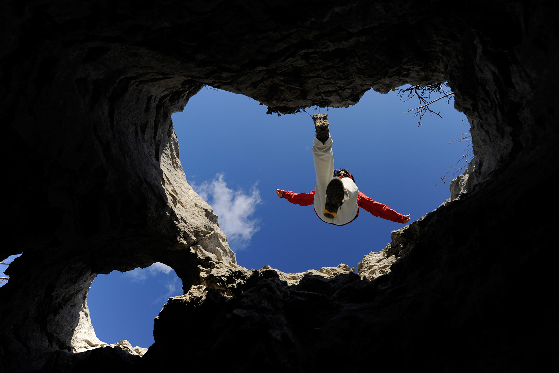 Randonneuse sautant au dessus d'un aven - Pic Saint Loup (Hérault)
