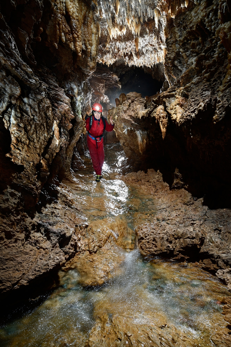 Grotte d'Orquette (Plateau d'Albès, Hérault) - Spéléo progressant dans la rivière souterraine avec un petit rapide en premier plan