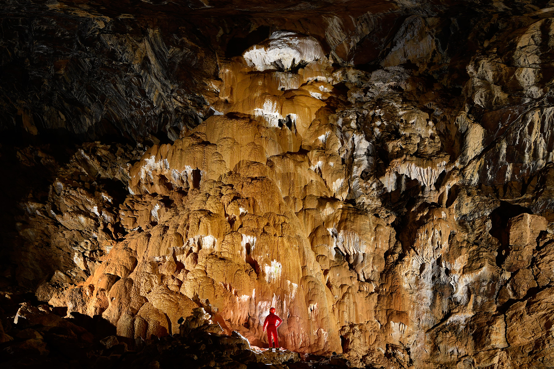 Grotte de Vallorbe (Suisse) - Dépôts de moonmilk (provenant de la décomposition des carbonates). Ils sont recouverts d'une couche de calcite orange.
