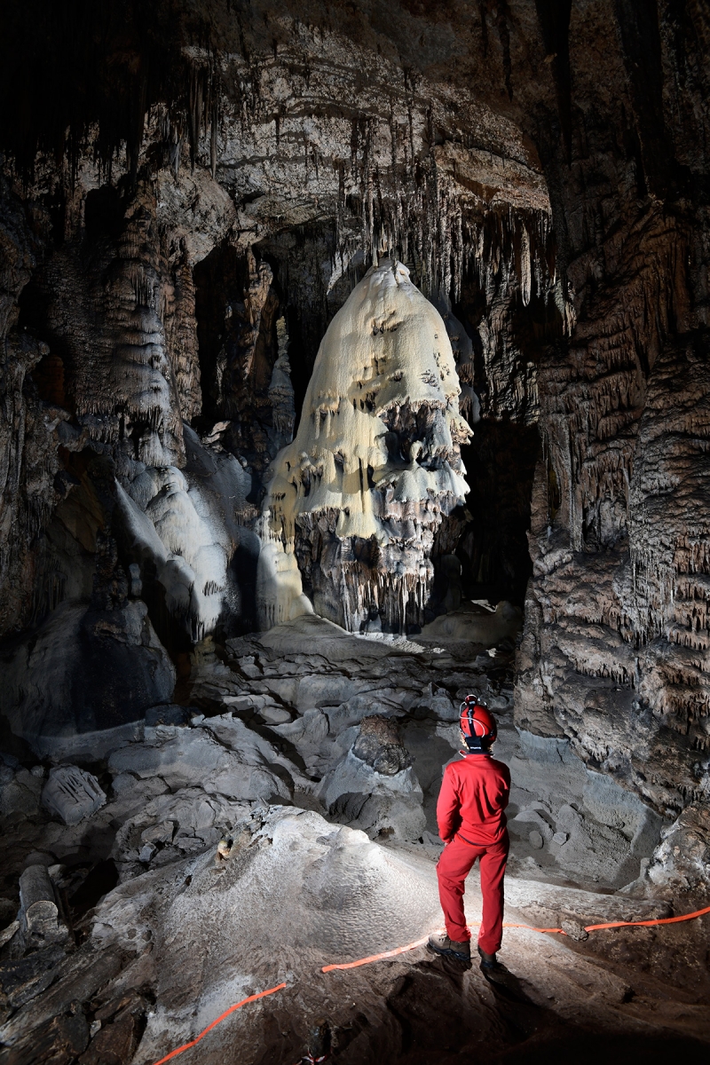 Slaughter Canyon Cave (USA - Nouveau Mexique) - Grand dôme de calcite jaune et grise avec spéléo en premier plan ("The Christmas Tree")