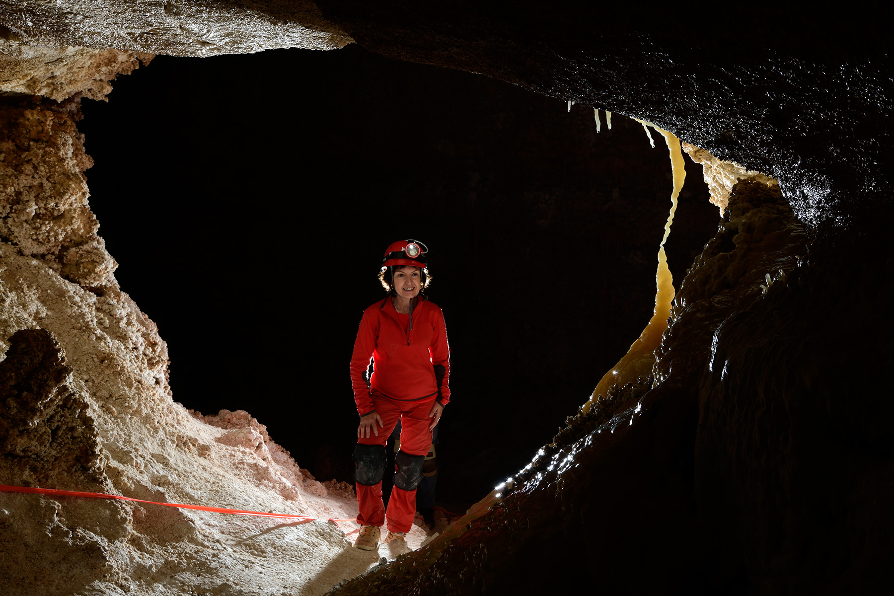 Hell Below Cave (USA - Nouveau Mexique) - Spéléo dans une petite galerie face à une fine concrétion jaune ("Moonlight Dancer")