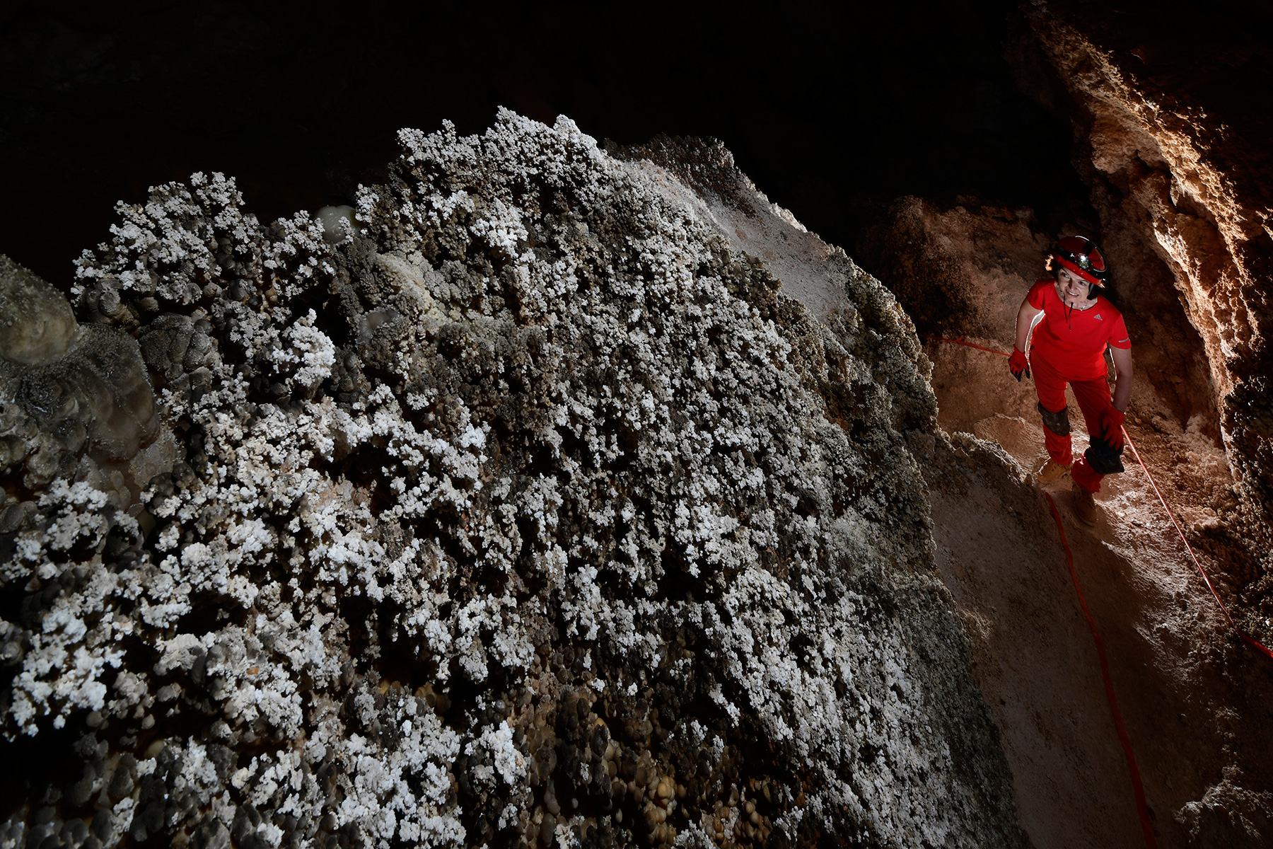 Hell Below Cave (USA - Nouveau Mexique) - Talus recouvert de concrétions en pop corn avec spéléo en contrebas