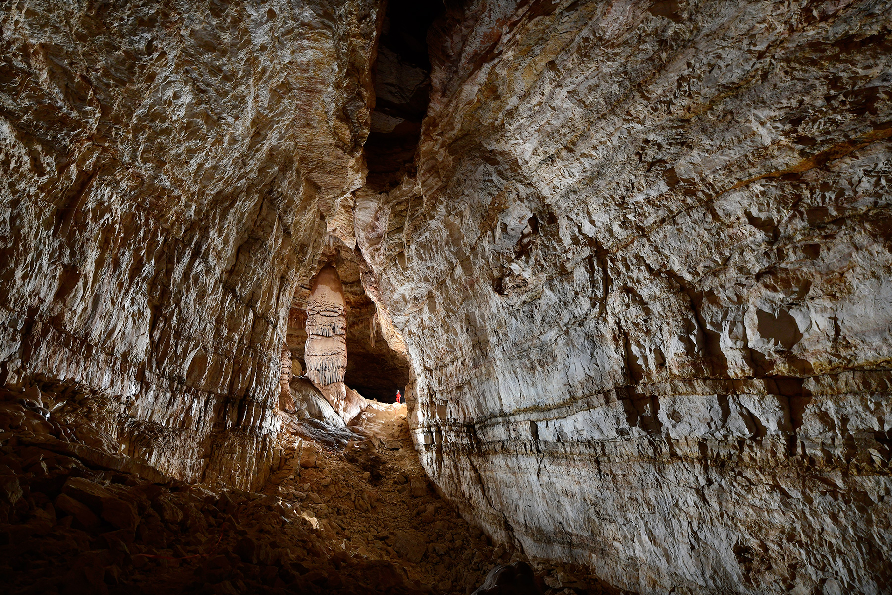 Cottonwood Cave (USA - Nouveau Mexique) - Grande galerie principale avec spéléo au pied d'une colonne massive en fond ("Main passage")