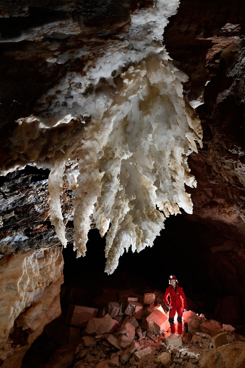 Cottonwood Cave Second Parallel (USA - Nouveau Mexique) - Grande galerie avec chandelier de gypse au plafond et spéléo en fond