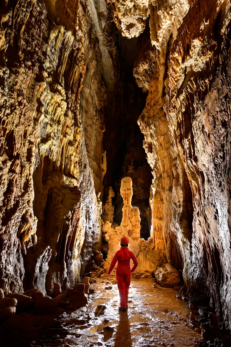 Gouffre des Ordons (Doubs) - Galerie avec grande stalagmite au milieu (spéléo de dos en premier plan)