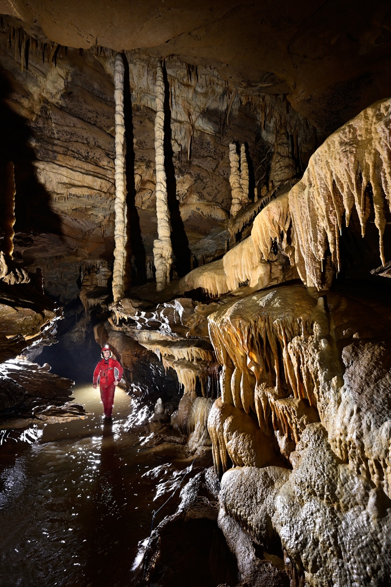 Grotte du Crotot (Doubs) - Galerie concrétionnée avec rivière et grandes colonnes en arrière plan