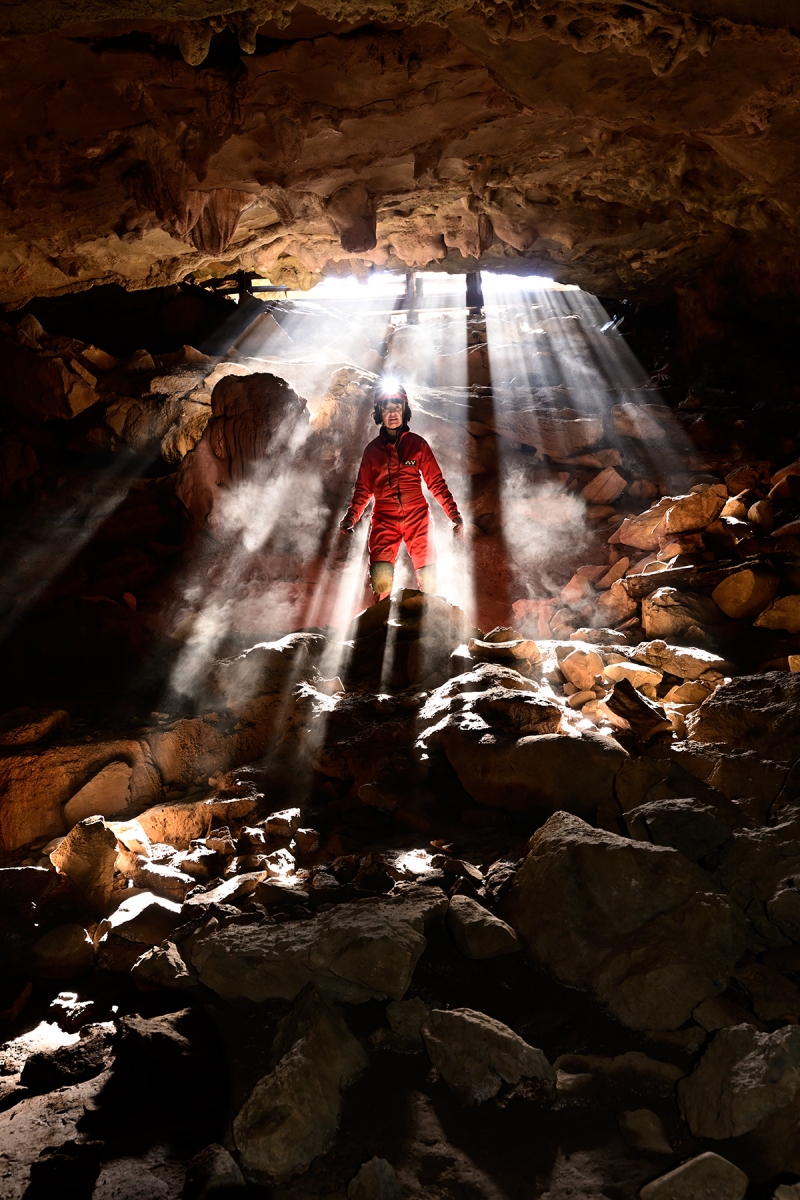 Rapps Cave  (Virginie occidentale, USA) - Spéléo dans l'entrée avec des rayons de soleil passant à travers la grille 