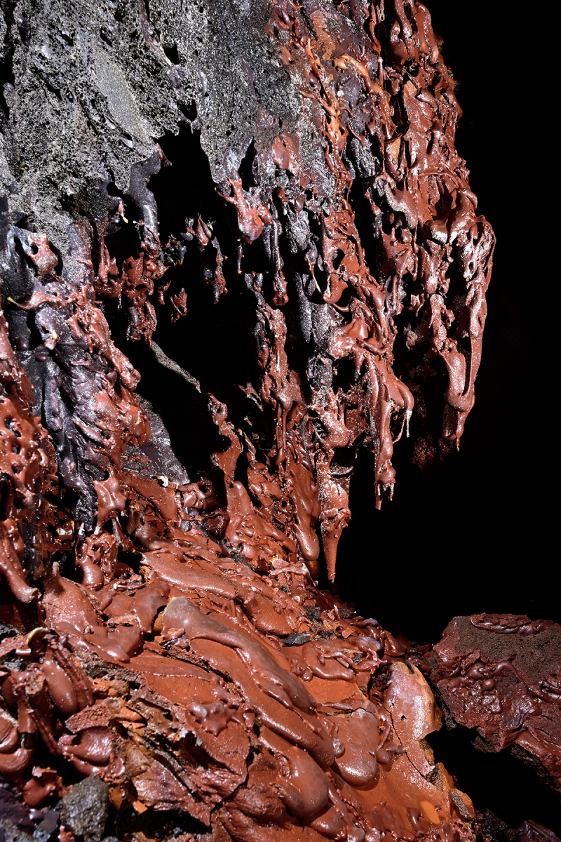 Tunnel de lave du Mapou (La Réunion) - Coulées rouges avec des stalactites sur une paroi