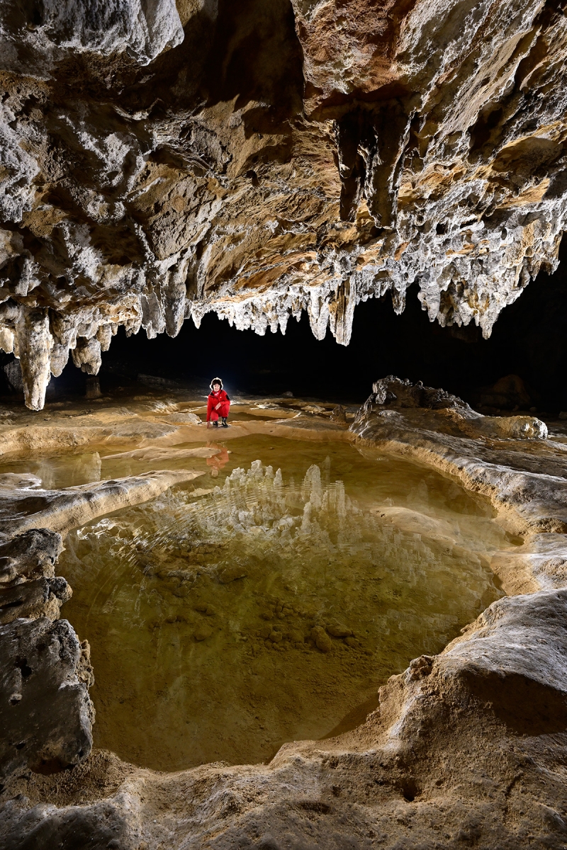 Grotte préhistorique de Bédeilhac (Ariège) - Vasque d'eau dans les alluvions constituant le plancher de la grotte, avec reflet de stalactites blanches (vertical)