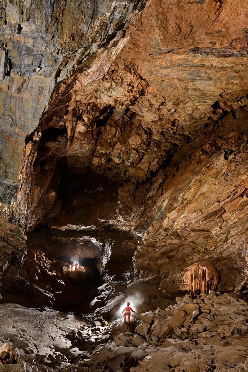 Grotte de La Douch (Hérault) - Grande salle avec deux spéléos (format portrait)