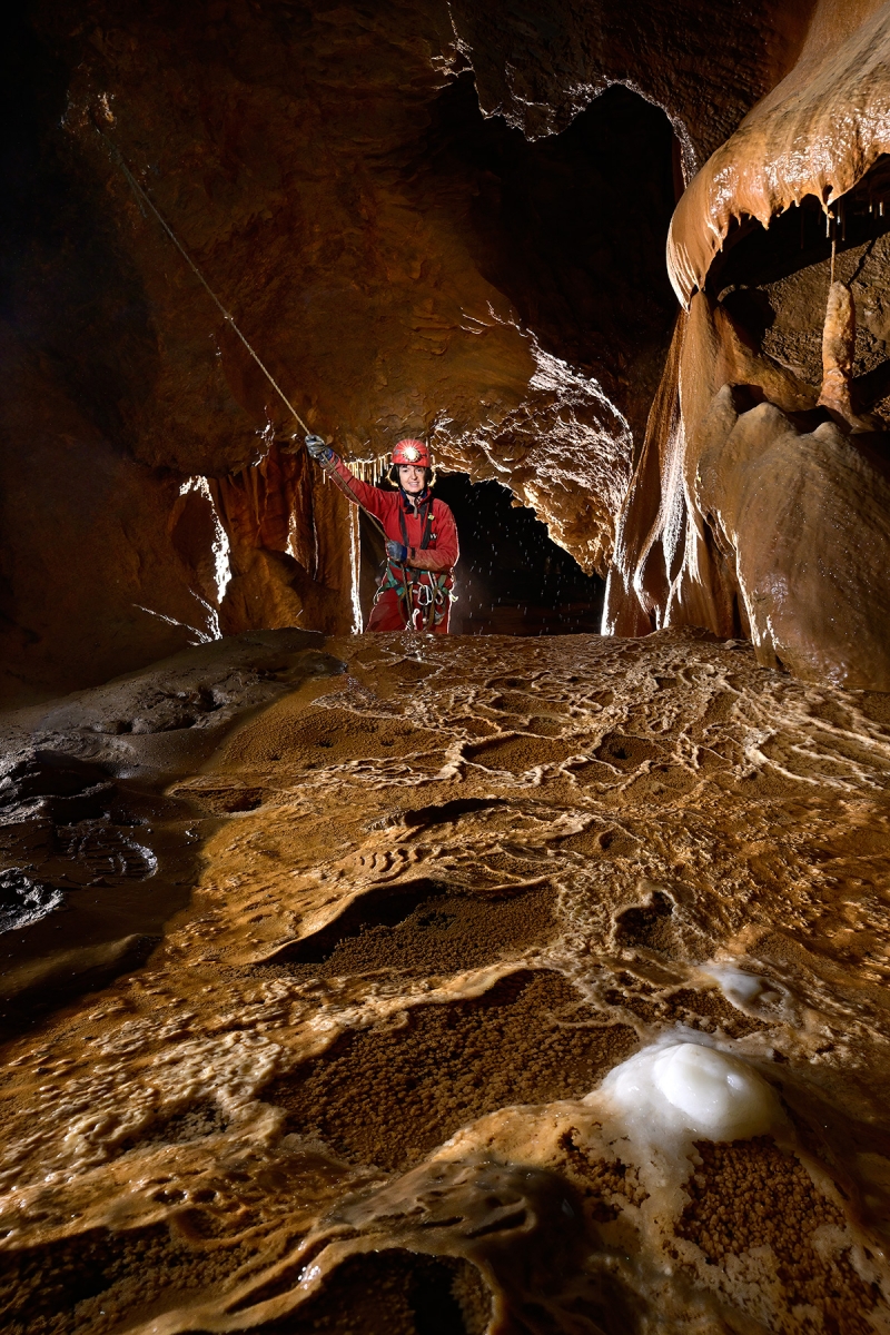 Grotte de La Douch (Hérault) - Ensemble de gours avec une stalagmite blanche (spéléo en arrière plan)