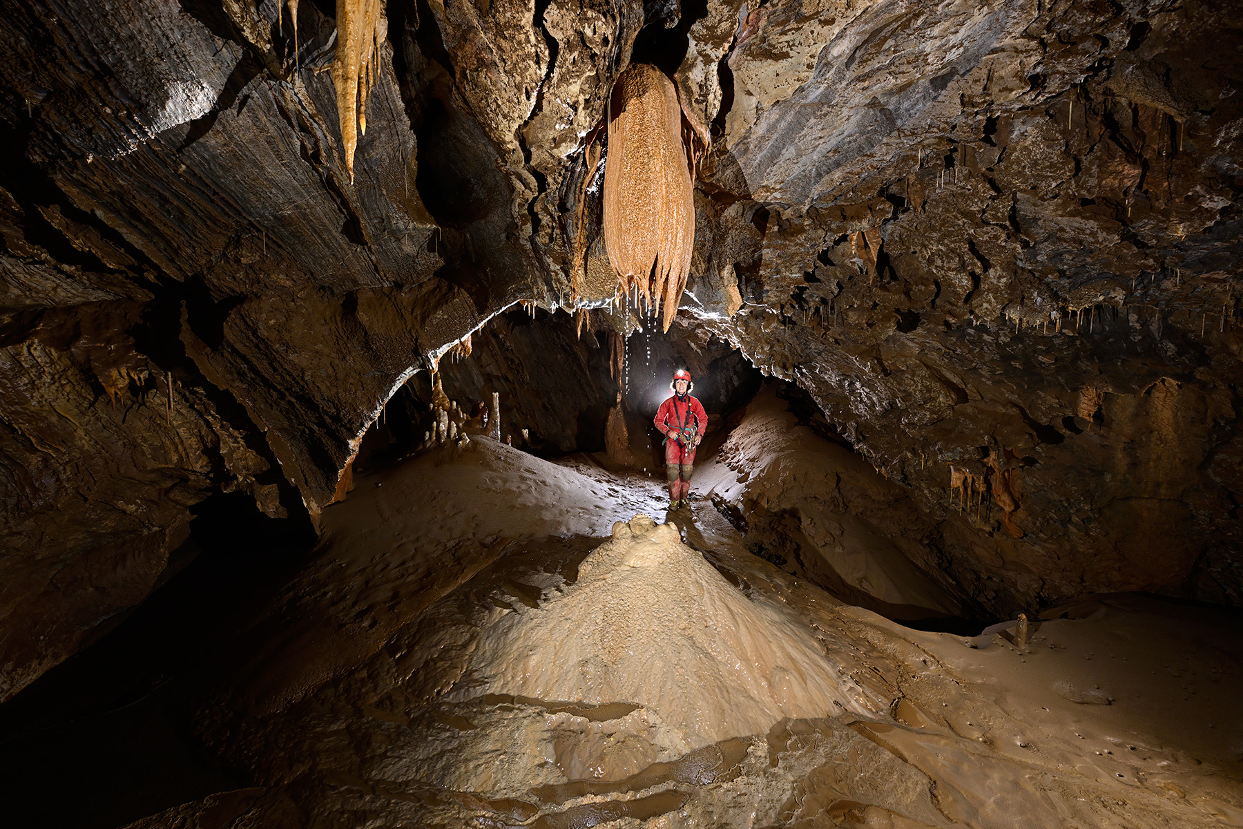 Grotte de La Douch (Hérault) - Alcôve sur le côté d'une galerie avec de l'eau tombant d'une stalactite massive sur un dôme de calcite 