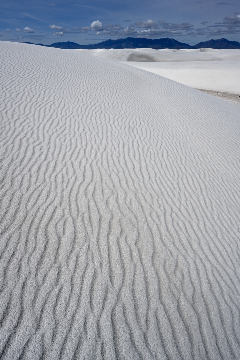 White Sands National Park (Nouveau Mexique, USA) - Détail des rides d'une dune de sable blanc avec montagne en fond