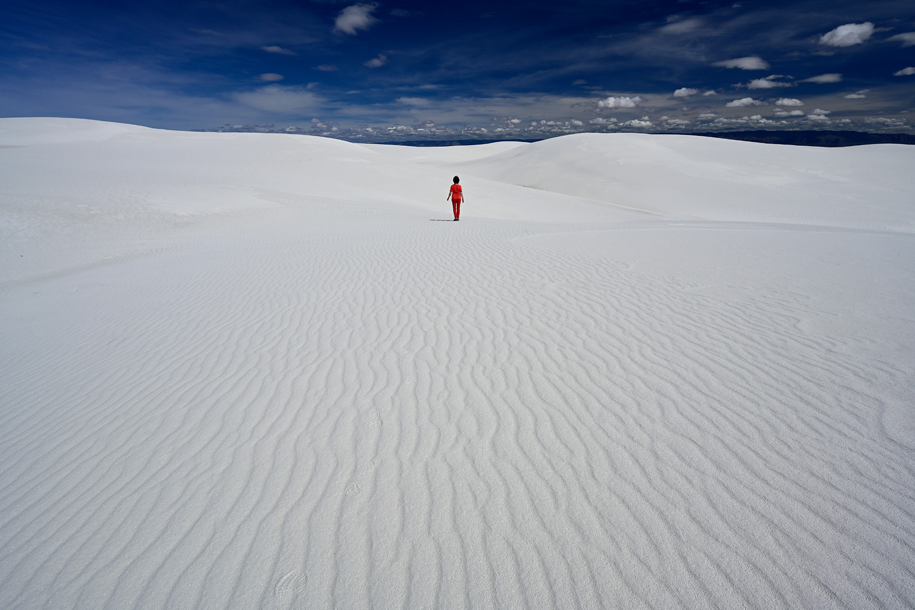 White Sands National Park (Nouveau Mexique, USA) - Personnage marchant au milieu des dunes de sable blanc (avec rides en premier plan)