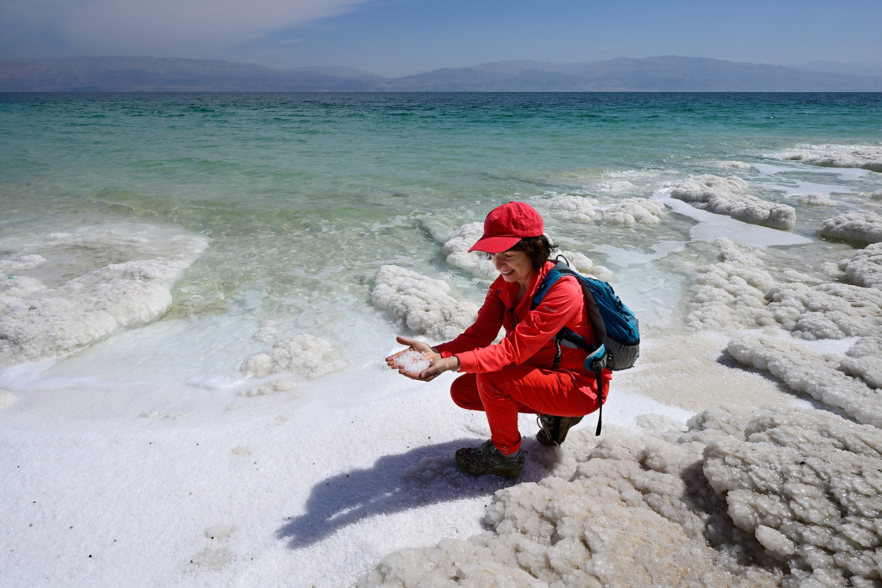Mer Morte (Israël) - Personnage tenant des perles de sel dans sa main sur le rivage de la Mer Morte vers Ein Gedi 