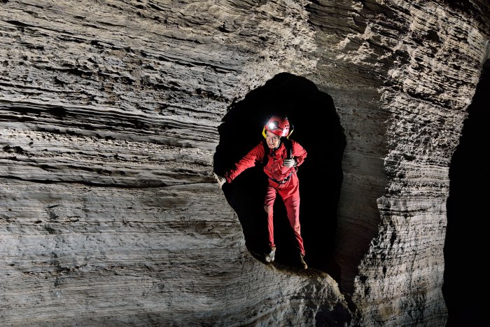 Le spéléologue évolue dans des passages bas, verticaux, étroits, sur des cordes ou en escalade