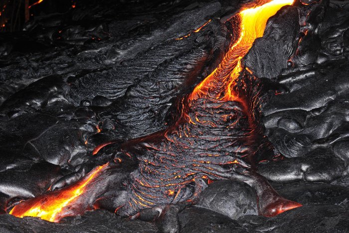 La plus grande île de l'archipel d'Hawaï, appelée Big Island, est le plus gros massif volcanique du monde. La lave provient d'un point chaud situé à presque 300 km de profondeur. Elle comprend cinq volcans, dont le Mauna Loa qui culmine à 4170 mètres d'altitude. Le plus jeune est le Kilauea, en éruption à peu près continuellement depuis 1983. Il émet régulièrement des coulées d'une lave très fluide qui s'écoulent jusqu'à l'océan. Le meilleur endroit pour l'observer est le Volcano National Park, mais ses émanations sulfureuses en interdisent souvent l'approche. Ses épanchements successifs ont créé de nombreux champs de laves où alternent les surfaces lisses et satinées de la poheohe au relief souvent cordé et aux reflets argentés, et les aa, plus noires, déchiquetées et hérissées de blocs instables. Le spectacle le plus saisissant est sans aucun doute l'approche de nuit des coulées qui descendent vers l'océan. Des langues rouges s'épanchent, se boursoufflent et se plissent au fur et à mesure qu'elles refroidissent, craquetant comme un pain chaud sorti du four.