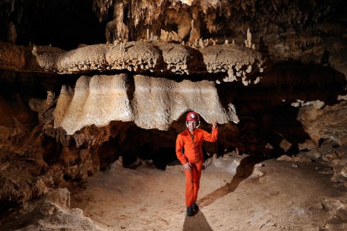 Cueva de Santa Catalina Expédition Cuba 2012 - Team La Salle. Spéléo debout sous une concrétion au plafond en forme de méduse.(SP-12-0128)