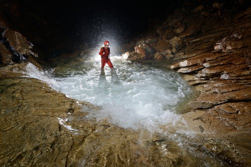 Good Luck Cave (Gunung Mulu National Park, Bornéo, Malaisie) - personnage remontant la rivière en aval de Sarawak Chamber.(SP-13-0659)