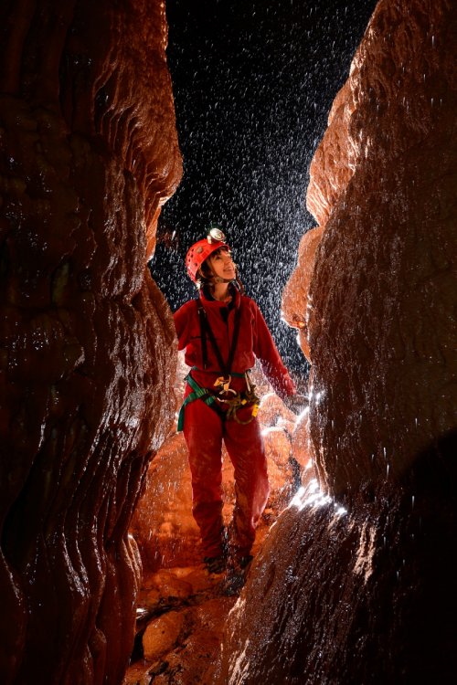Aven d'Orgnac - Issirac - Salle rouge : spéléo dans passage calcifié avec pluie de gouttelettes contre-jour(SP-14-0094)