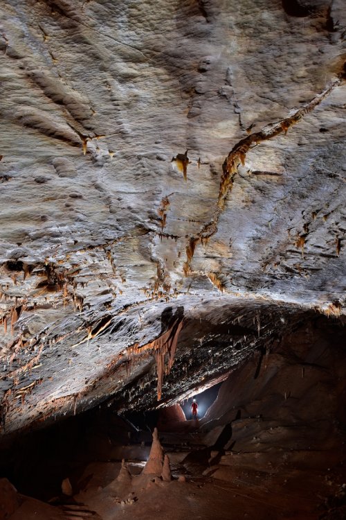 Lipiska Jama (Slovénie) - galerie avec plafond lisse (spéléo contre-jour en arrière plan)(SP-17-0385)