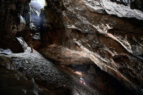 Dimnice Jama (Slovénie) - Deux spéléos dans une grande salle éclairée par la lumière d'un puits(SP-17-0478)