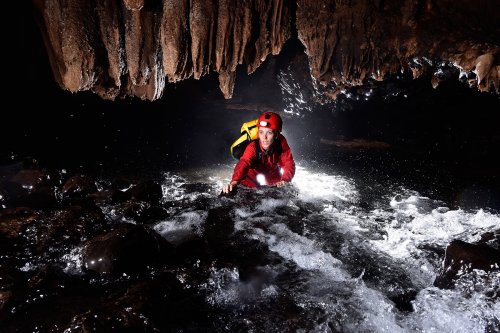 Lapa Sao Matheus II (Sao Domingos, Goiás) - Spéléo remontant la rivière dans un rapide.(SP-16-0636)