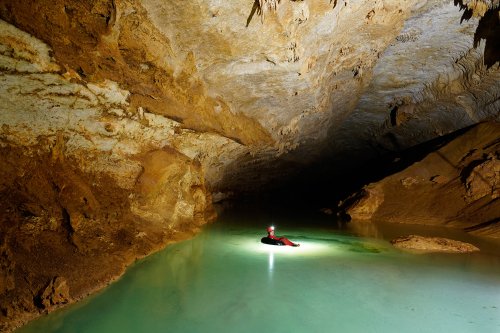 Lapa do Convento (Lage dos Negros, Bahia) - Spéléo progressant dans une bouée dans une rivière couverte de calcite flottante.(SP-16-1103)