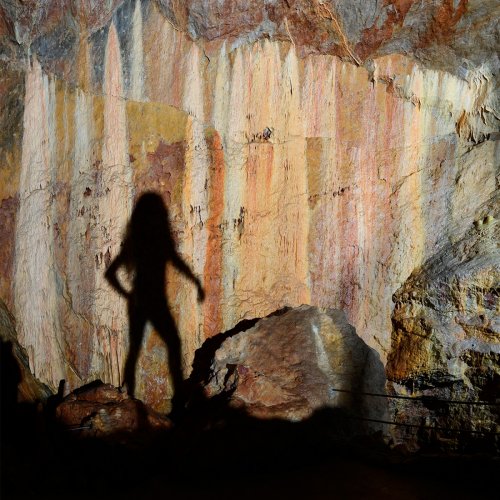 Grotte de Dargilan partie touristique (Lozère) - Ombre projetée sur la paroi couverte de coulées de calcite colorées au début de la salle du Chaos.(SP-18-0226)