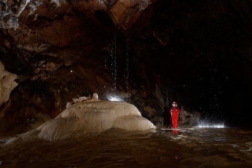 Grotte de Lombrives (Ariège) - "Le tombeau de Pyrène" : personnage devant le massif stalagmitique sur lequel tombe l'eau du plafond(SP-18-1396)