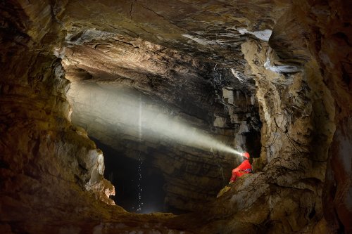 Grotte de Vallorbe (Suisse) - Spéléo éclairant avec sa lampe Scurion une cascatelle (SP-18-1592)