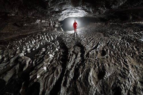 Grotte du Hölloch (Suisse) - Galerie en conduite forcée avec planché érodé par l'eau (spéléo en contre-jour en fond)(SP-18-1615)