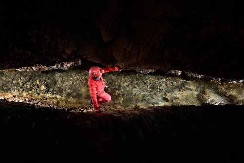 Grotte de Pont de Ratz (Hérault) - Spéléo progressant dans la rivière au fond d'une diaclase (SP-19-0030)