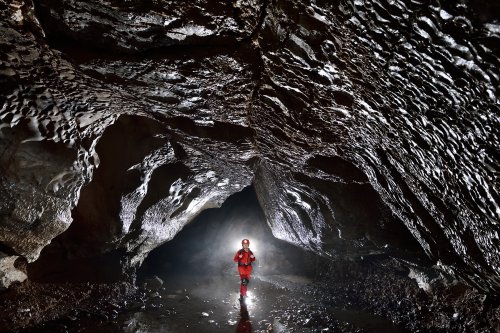 Kagekiyo-ana (Akiyoshidai, Yamaguchi, Japon) - Spéléo progressant dans galerie sombre avec rivière souterraine (SP-19-0223)
