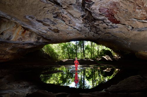 Gruta Aroe Eiari (Mato Grosso, Brésil) - Entrée se reflétant dans l'eau avec personnage au centre.(SP-19-1325)