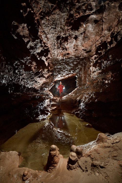 Grotte du sergent (Hérault) - Petite galerie rectangulaire  avec laisse d'eau. Par rapport à la photo précédente "basique", il a été décidé de donner plus de profondeur à la galerie. Un flash a été ajouté sur le sol, caché par un bloc, pour éclairer en contre-jour le plafond tandis qu'un autre flash éclairait le premier plan. (SP-19-2085)