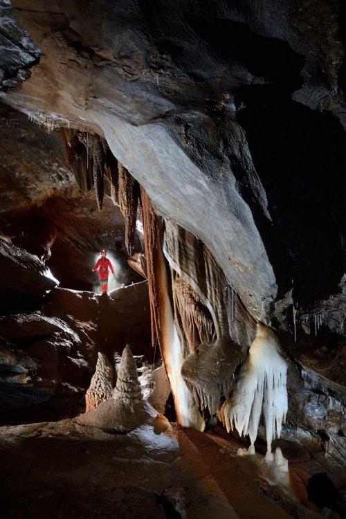 Grotte de Roquebleue (Hérault) - Galerie concrétionée avec des draperies (spéléo contre-jour en fond)(SP-20-0056)